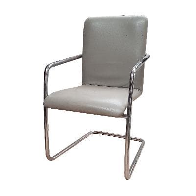 Sillón en metal cromado con tapicería de piel gris.