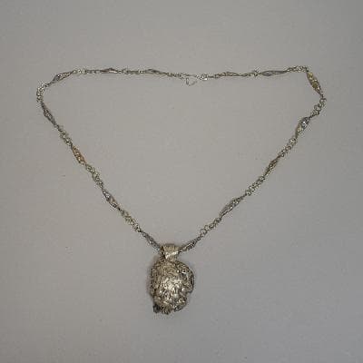 Collar con dije estilo Brutalista en metal plateado